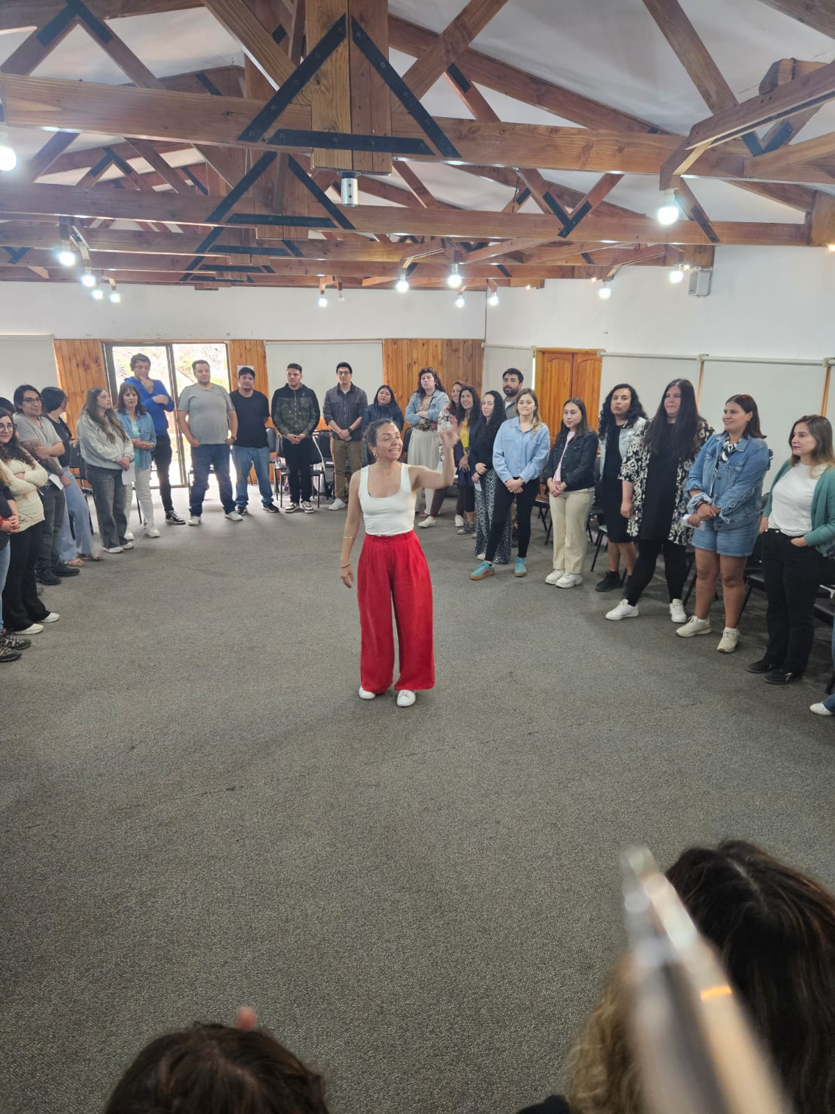 Cecilia María Aguirre dirigiendo un ejercicio teatral con un equipo en círculo